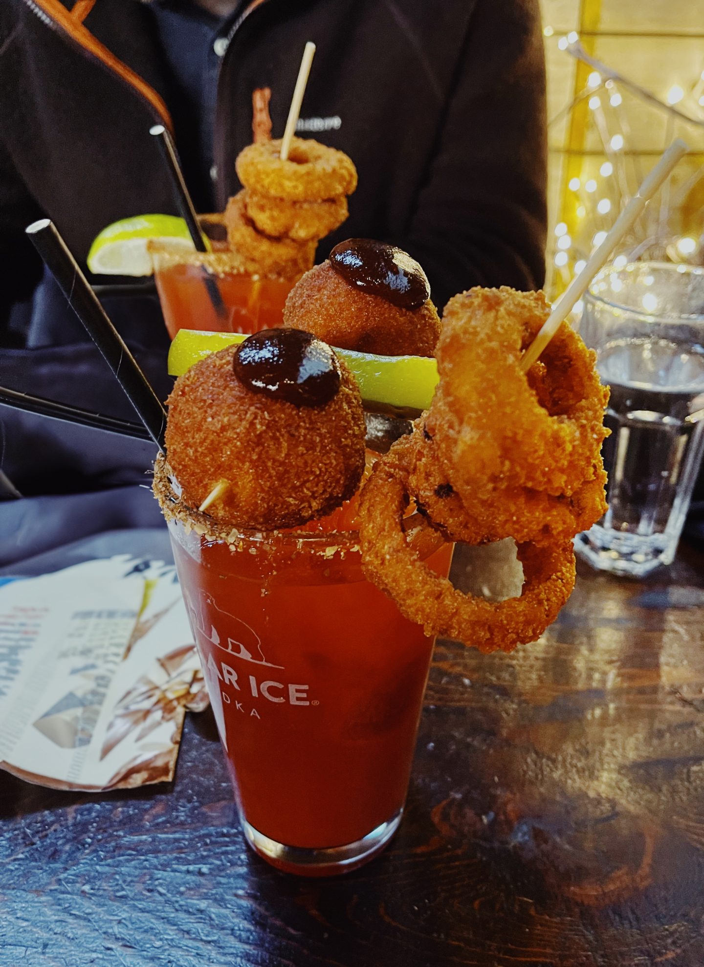 An extravagant Caesar with onion rings and cheese balls at Score in Vancouver BC