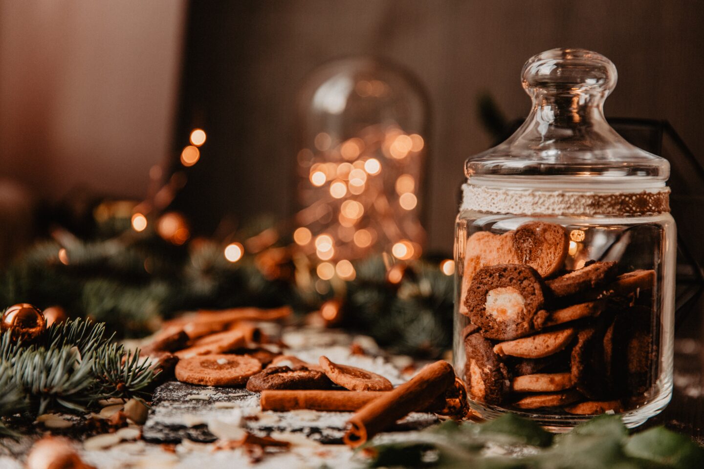 Gingerbread cookies in a jar surrounded by fairy lights and pine